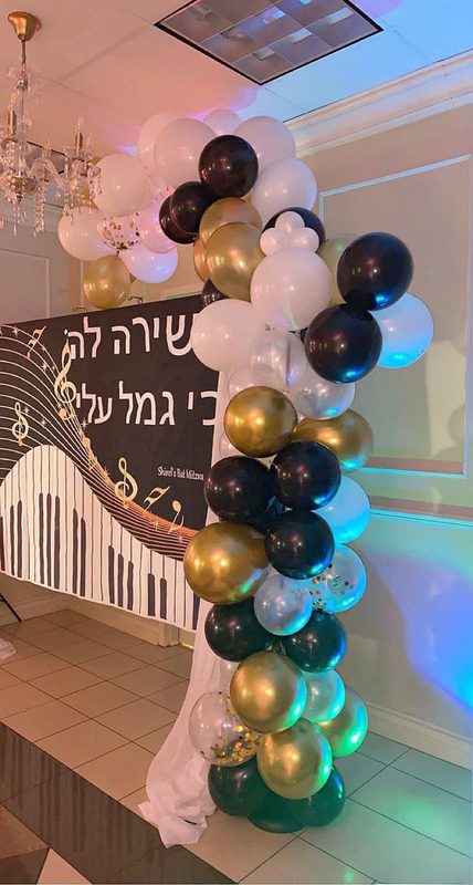 Black, gold and white balloon column at an event