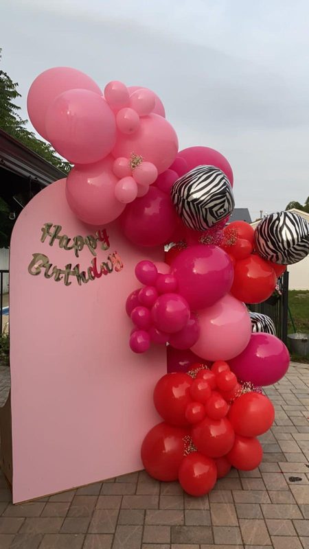 Pink and red balloons on a Happy Birthday backdrop